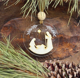 Decorative Christmas ornament with nativity scene on a wooden background