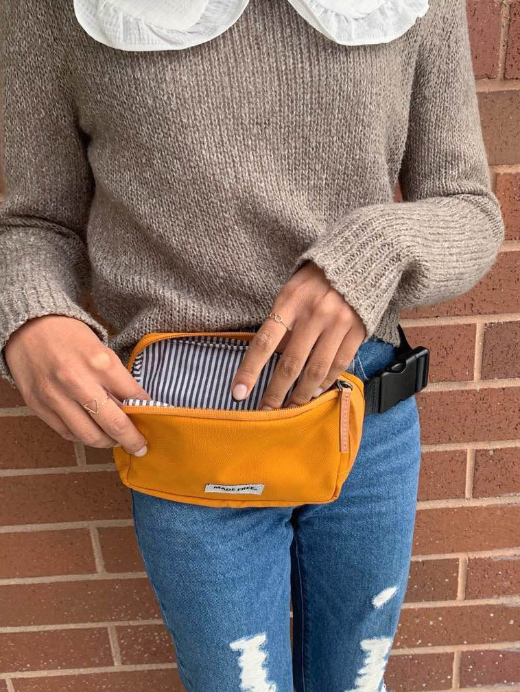 orange fanny pack with striped lining on the inside made free