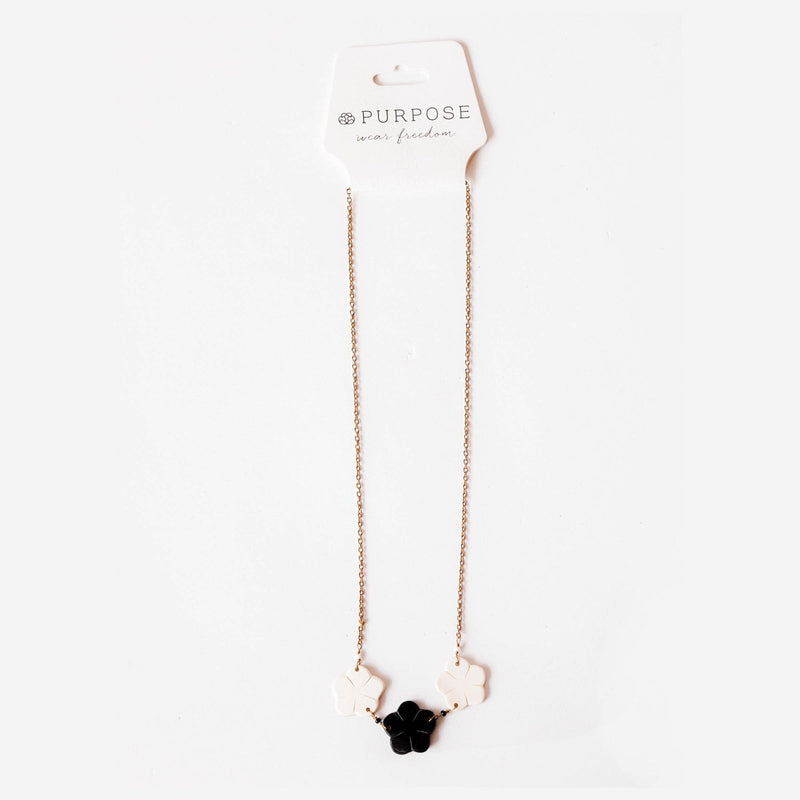 gold chain necklace with white and black flowers